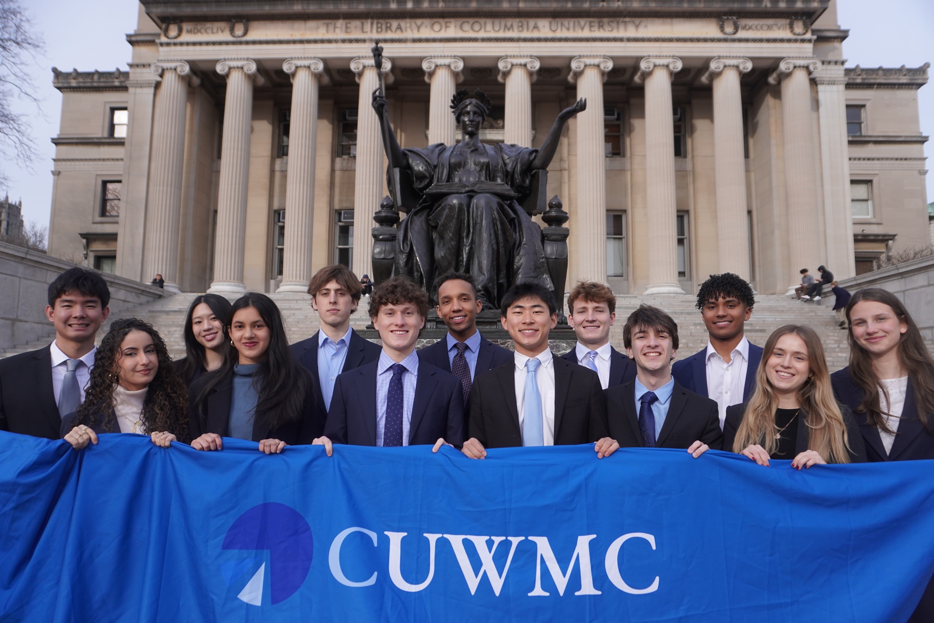 CUWMC analysts holding the club banner on the steps of Low Library